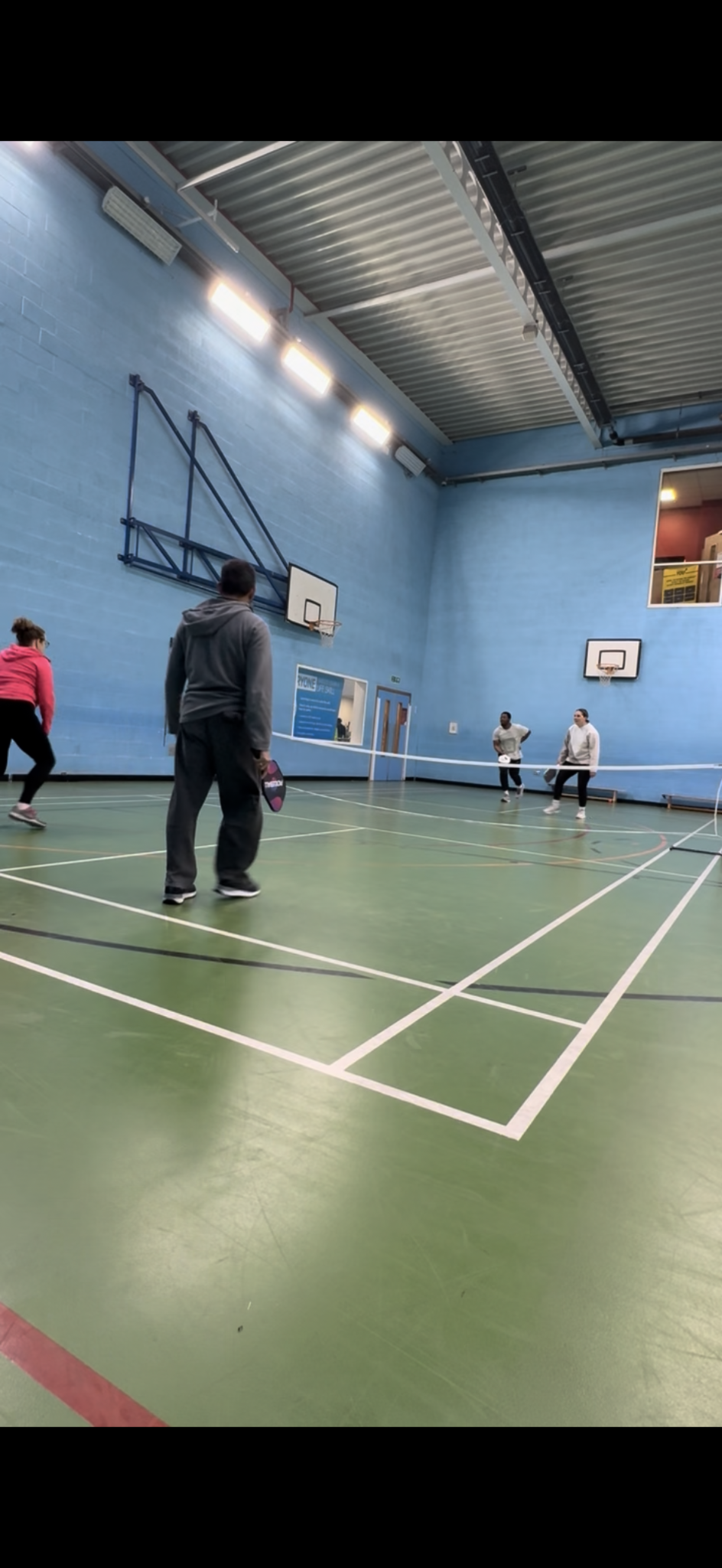 Players enjoying doubles pickleball on the green court at Watford Central
