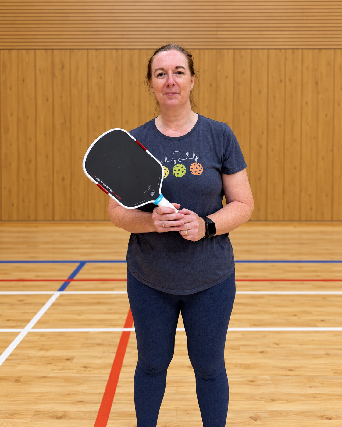 Lisa holding her Boomstik-style pickleball paddle